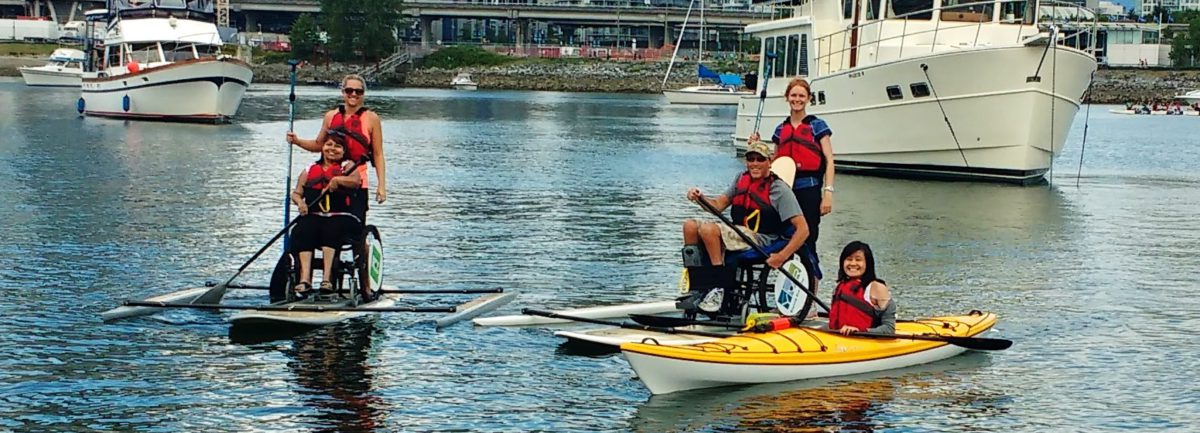 Group of paddle boarders and kayakers posing on the water.