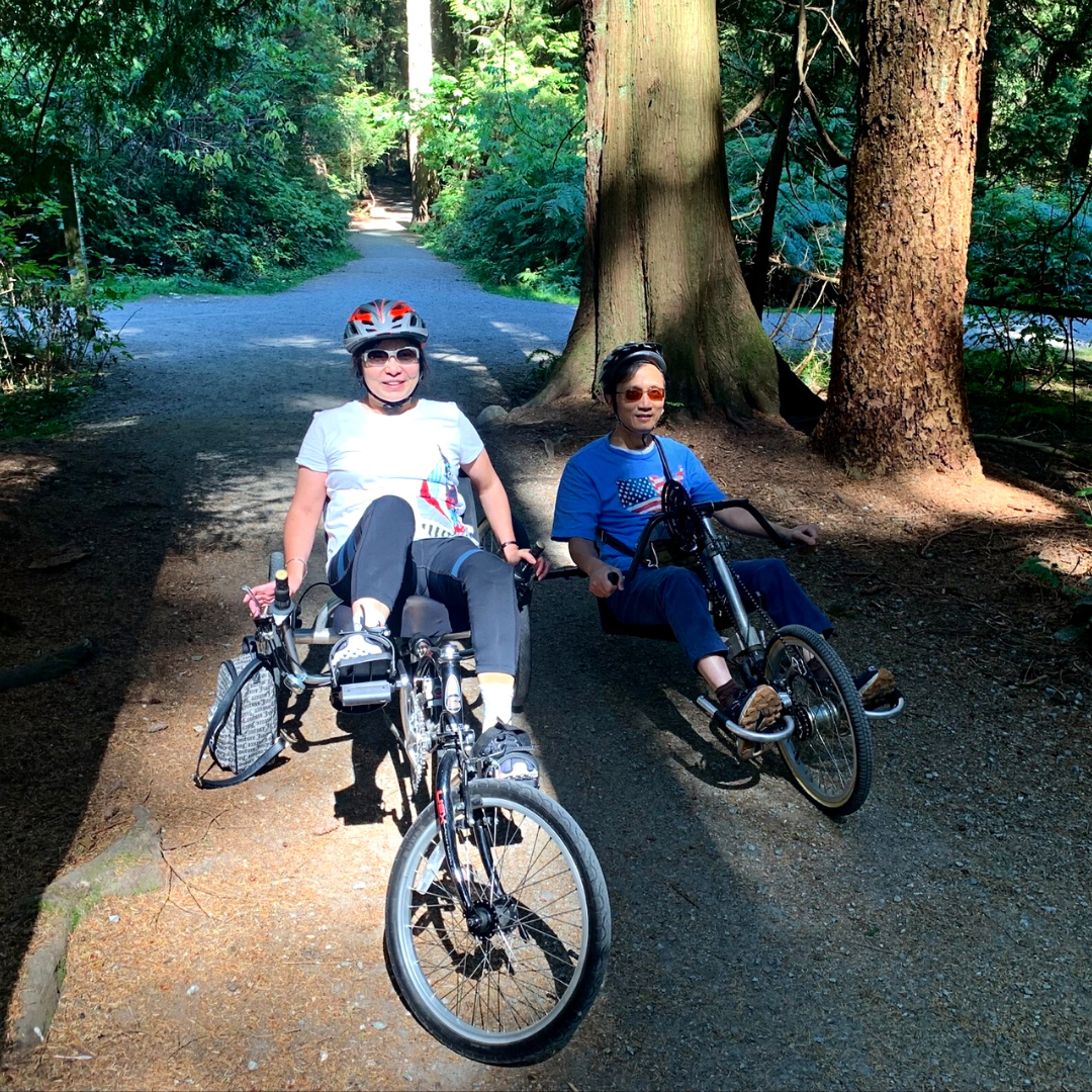 Two people sitting in adaptive bikes